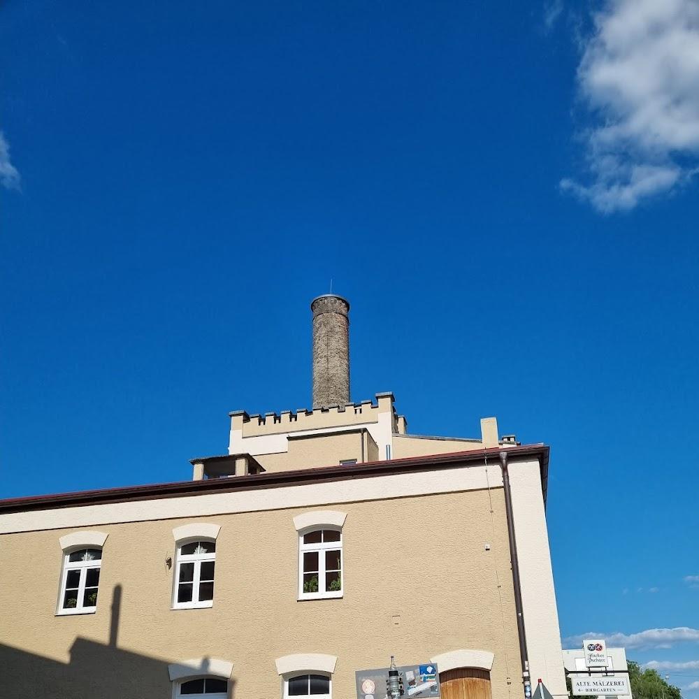 A tall chimney atop a building with windows. The building is labeled